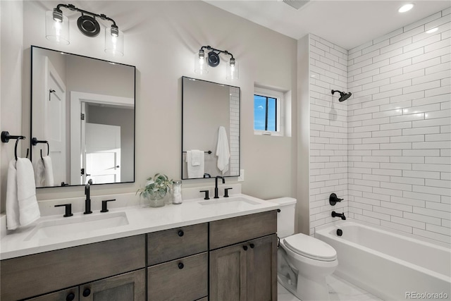 full bathroom with vanity, tiled shower / bath combo, and toilet