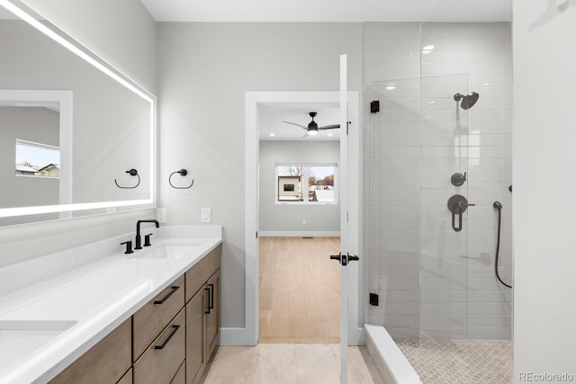 bathroom with a tile shower, tile patterned flooring, and vanity