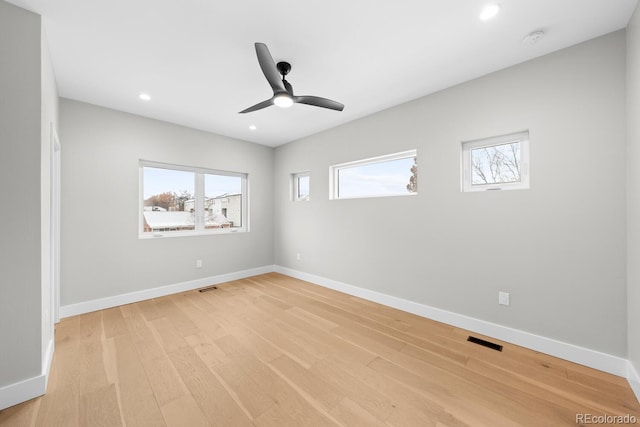 unfurnished room featuring light wood-type flooring, a wealth of natural light, and ceiling fan