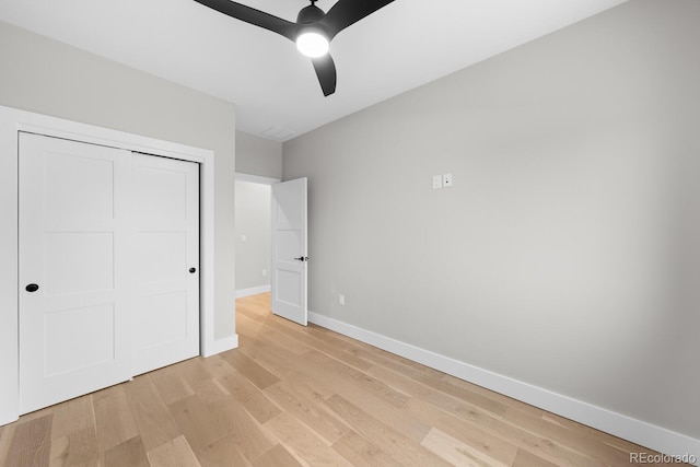 unfurnished bedroom featuring ceiling fan, light wood-type flooring, and a closet