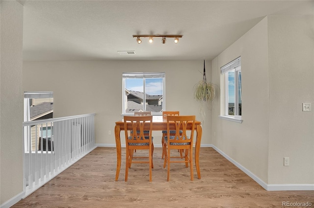 dining area with a textured ceiling and light wood-type flooring