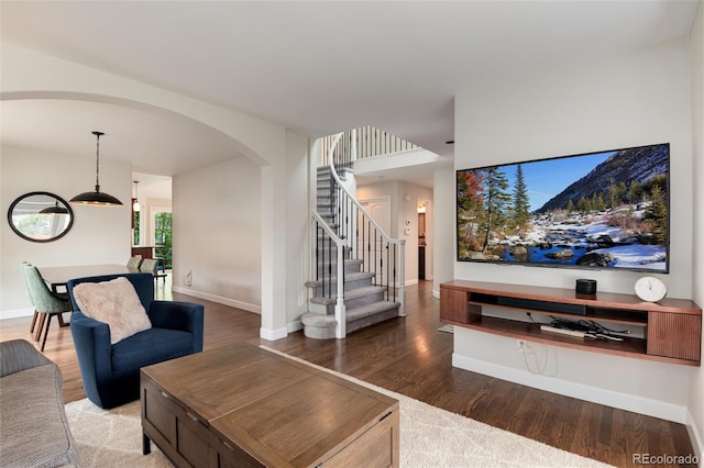 11056 W Rowland Ave, Littleton, CO 80127 - living room with arched walkways, wood finished floors, stairs, and baseboards