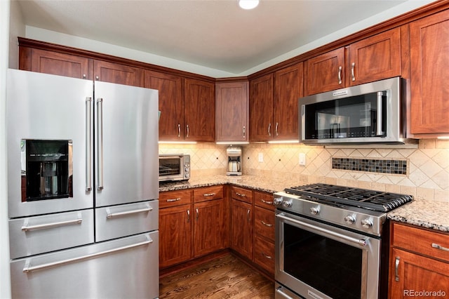 11056 W Rowland Ave, Littleton, CO 80127 - kitchen featuring stainless steel appliances, light stone counters, wood finished floors, and tasteful backsplash
