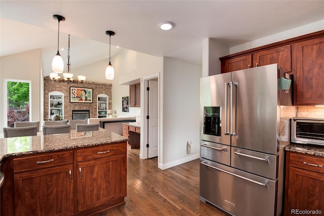 11056 W Rowland Ave, Littleton, CO 80127 - kitchen featuring high end refrigerator, dark wood finished floors, a large fireplace, light stone counters, and baseboards