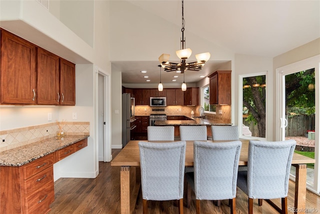 11056 W Rowland Ave, Littleton, CO 80127 - dining space featuring dark wood finished floors, a chandelier, vaulted ceiling, and recessed lighting