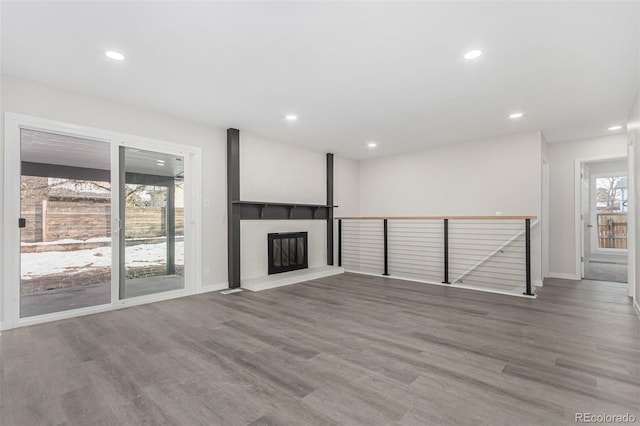 unfurnished living room with hardwood / wood-style flooring and a brick fireplace