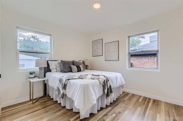 bedroom featuring multiple windows and light wood-type flooring