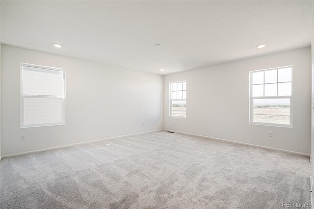 carpeted spare room featuring a healthy amount of sunlight