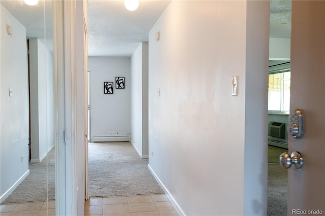 hall with light carpet, a textured ceiling, baseboard heating, and light tile patterned floors