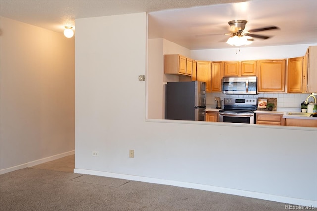 kitchen with ceiling fan, light colored carpet, stainless steel appliances, light countertops, and tasteful backsplash