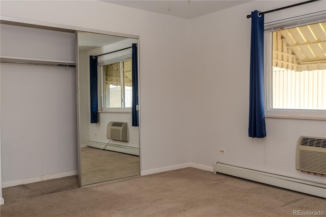 unfurnished bedroom with an AC wall unit, baseboard heating, and carpet floors