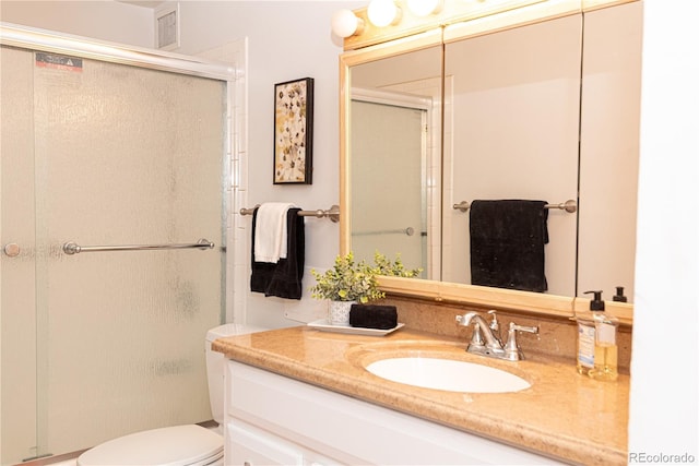 full bath featuring toilet, a stall shower, and vanity