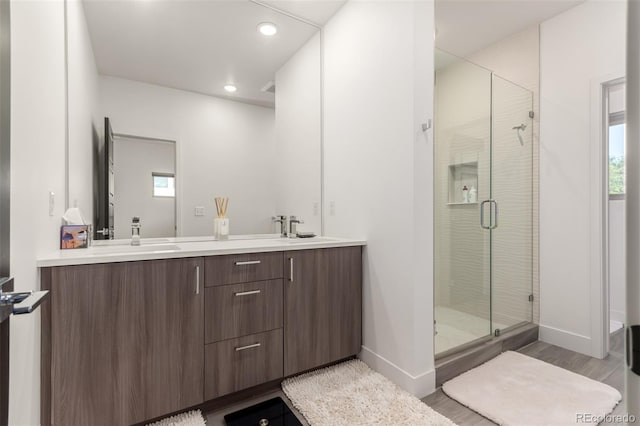 3586 S Ogden St, Englewood, CO 80113 - bathroom with a shower stall, double vanity, wood finished floors, recessed lighting, and plenty of natural light