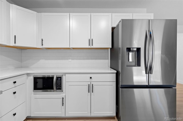 3036 Wolff St S, Denver, CO 80236 - kitchen featuring stainless steel appliances, light countertops, white cabinetry, and backsplash