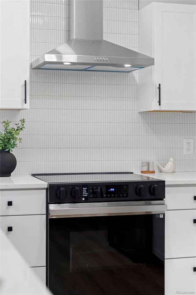 3036 Wolff St S, Denver, CO 80236 - kitchen featuring wall chimney range hood, range with electric cooktop, white cabinets, decorative backsplash, and light countertops