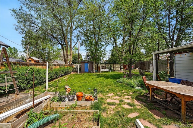 view of yard featuring a garden, a storage shed, and an outbuilding