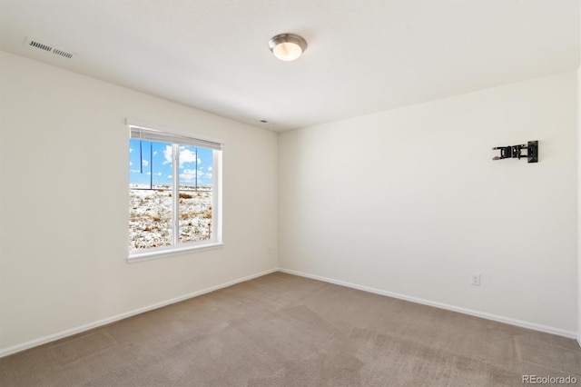 spare room with baseboards, visible vents, and light colored carpet