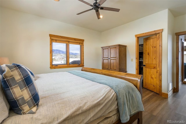 bedroom with baseboards, visible vents, ceiling fan, and wood finished floors