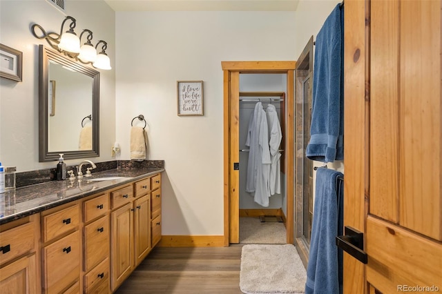 bathroom with vanity, baseboards, and wood finished floors