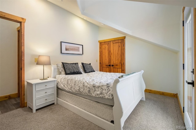 carpeted bedroom featuring vaulted ceiling and baseboards