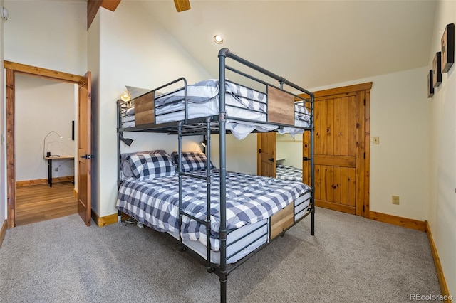 bedroom with lofted ceiling, carpet, and baseboards