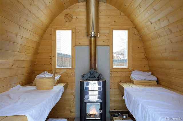 bedroom with lofted ceiling, wood walls, and wood ceiling