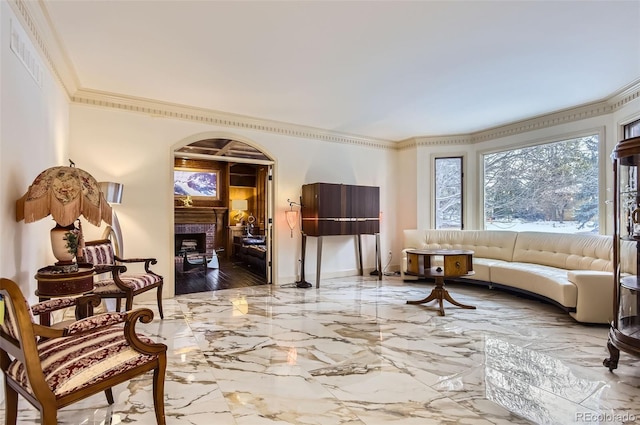 living area featuring crown molding and a brick fireplace