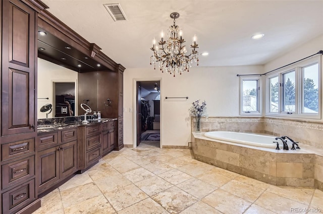 bathroom featuring a relaxing tiled tub and vanity