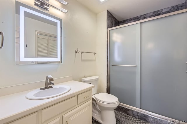 bathroom featuring vanity, toilet, and a shower with shower door