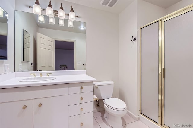 bathroom with a shower with door, vanity, tile patterned floors, and toilet