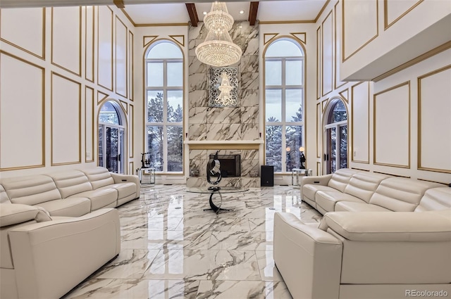 4681 S Columbine Ct, Cherry Hills Village, CO 80113 - living room with a decorative wall, a towering ceiling, marble tiled flooring, a chandelier, and a fireplace