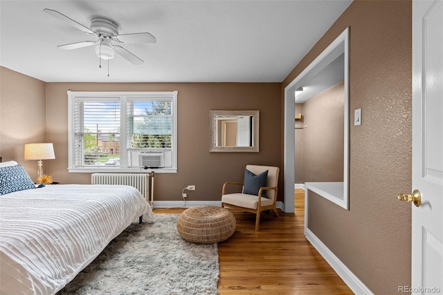 2867 Jasmine St, Denver, CO 80207 - bedroom featuring radiator heating unit, light wood-style flooring, ceiling fan, and cooling unit