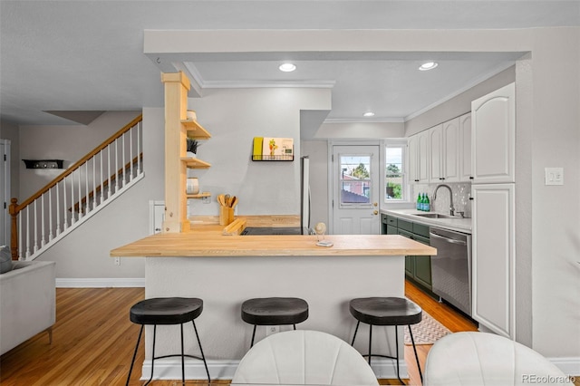 2867 Jasmine St, Denver, CO 80207 - kitchen featuring dishwasher, a breakfast bar, light wood finished floors, a peninsula, and white cabinets