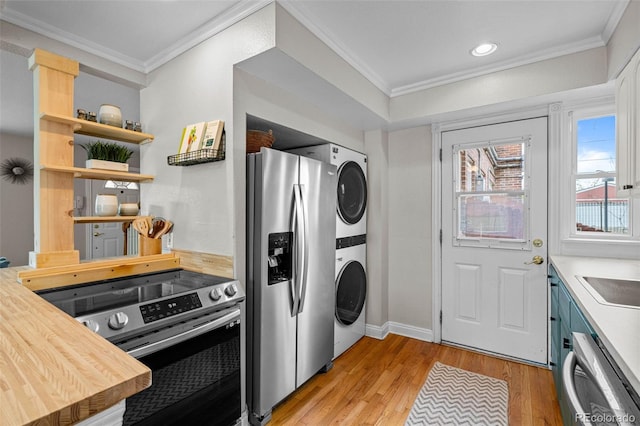 2867 Jasmine St, Denver, CO 80207 - kitchen with stainless steel appliances, estacked washer and dryer, ornamental molding, light wood-style flooring, and recessed lighting
