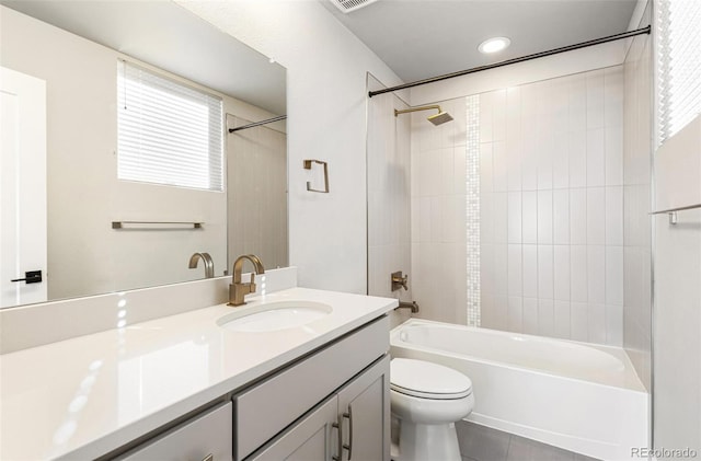 full bathroom featuring vanity, toilet, tiled shower / bath, and a wealth of natural light