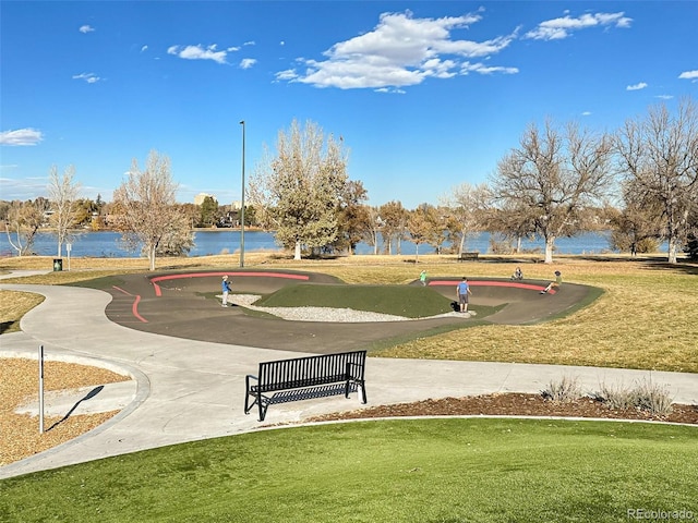 view of property's community with a lawn and a water view