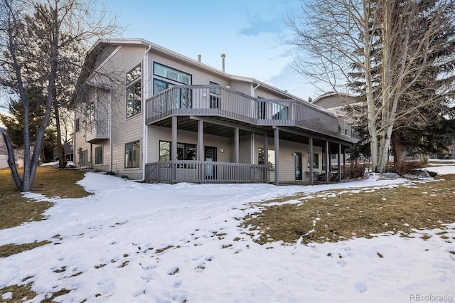 snow covered property with a deck