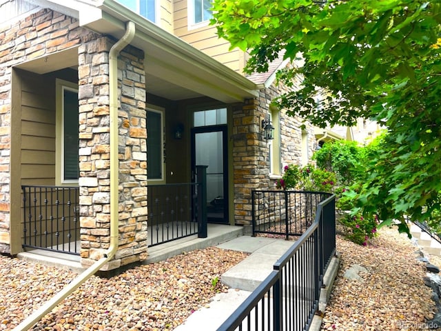 11282 Osage Cir N Unit F, Northglenn, CO 80234 - entrance to property featuring stone siding and a porch