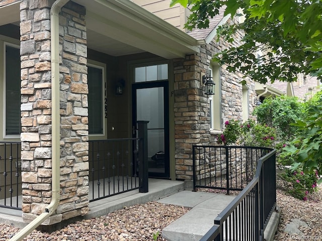 11282 Osage Cir N Unit F, Northglenn, CO 80234 - doorway to property with stone siding and a porch