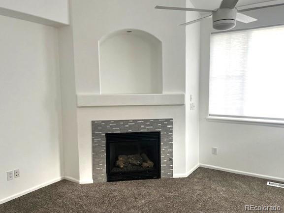 11282 Osage Cir N Unit F, Northglenn, CO 80234 - unfurnished living room with ceiling fan, carpet flooring, a tile fireplace, and baseboards