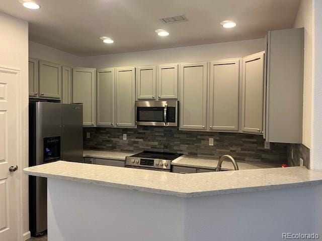 11282 Osage Cir N Unit F, Northglenn, CO 80234 - kitchen with stainless steel appliances, tasteful backsplash, a peninsula, recessed lighting, and a sink