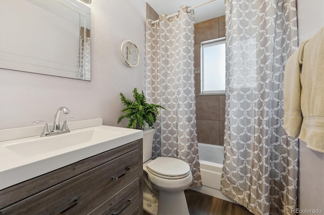 full bathroom featuring hardwood / wood-style flooring, shower / tub combo with curtain, vanity, and toilet