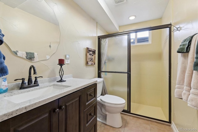 bathroom with tile patterned flooring, vanity, toilet, and walk in shower