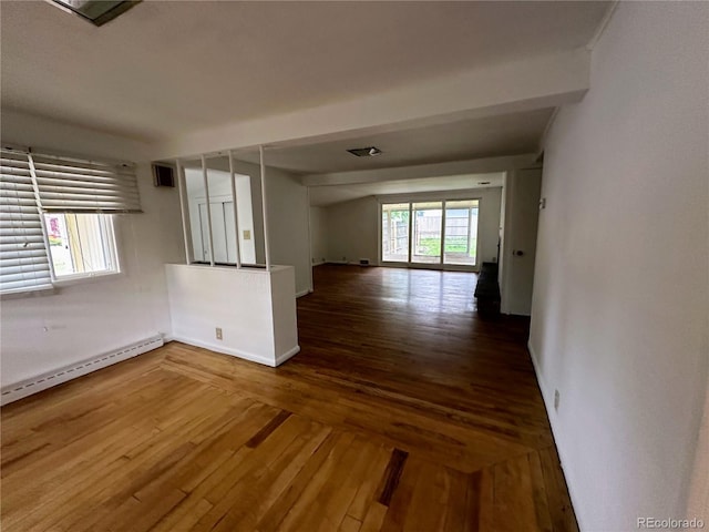 empty room featuring a baseboard radiator and hardwood / wood-style floors