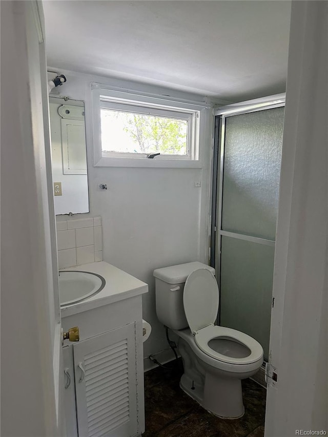 bathroom with toilet, walk in shower, and vanity