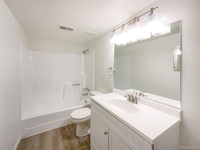 full bathroom with hardwood / wood-style flooring, vanity, shower / bathtub combination, and toilet