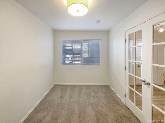 carpeted empty room featuring french doors