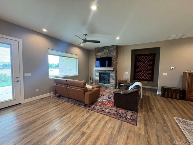 living room with hardwood / wood-style floors, ceiling fan, and a fireplace