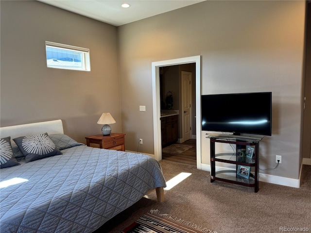 bedroom featuring connected bathroom and carpet