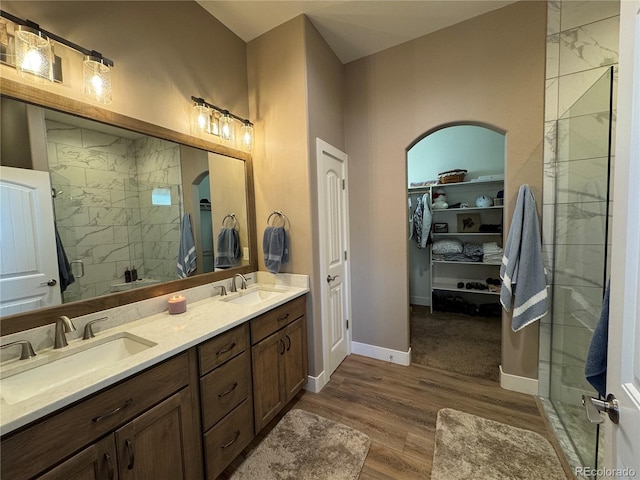 bathroom featuring hardwood / wood-style flooring, vanity, and a shower with door